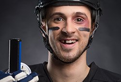 Man in hockey gear with missing tooth