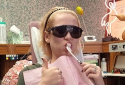Patient brushing teeth in dental chair
