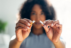 Woman snapping cigarette in half