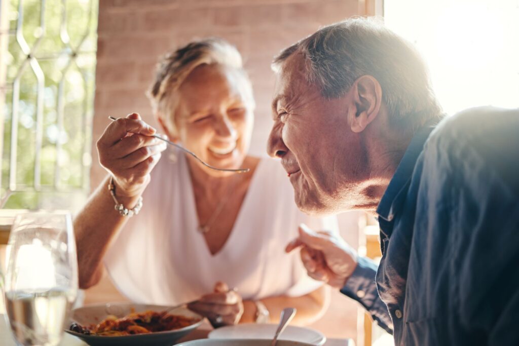 An older couple eating dinner together.