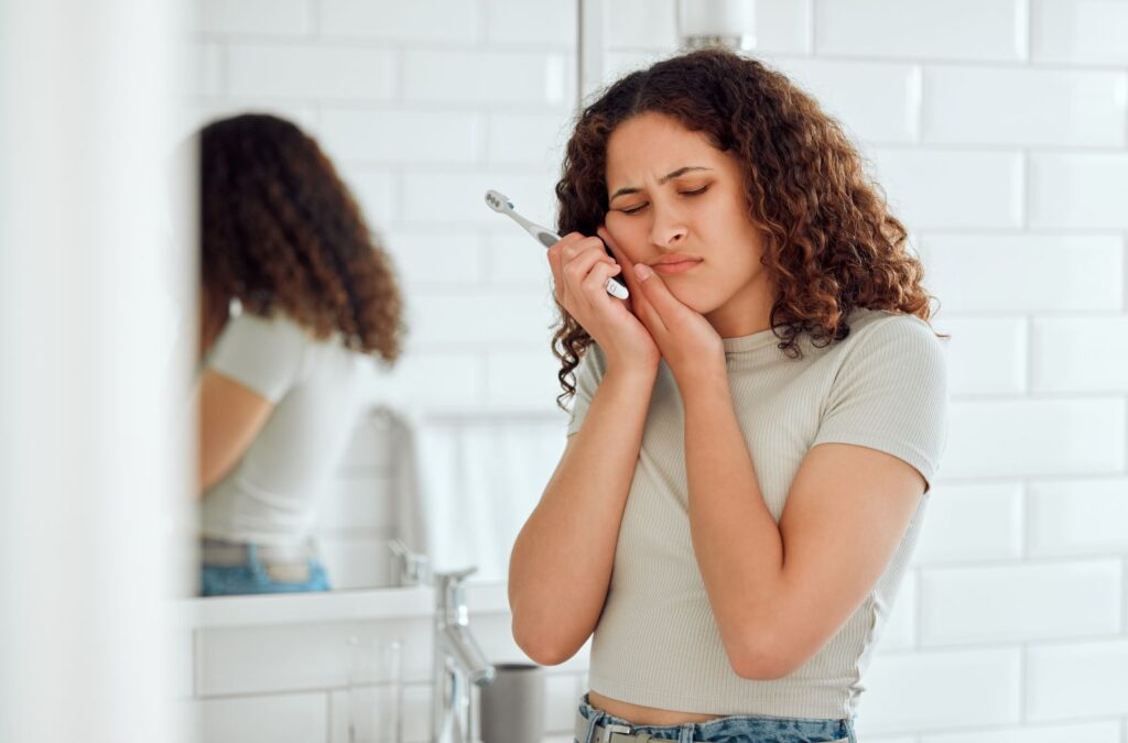 A woman holding her jaw in pain